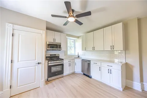 a kitchen with cabinets stainless steel appliances and a window