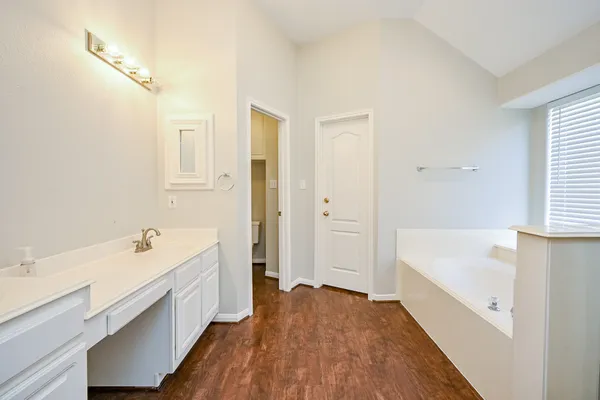 a bathroom with a bathtub a sink and a window