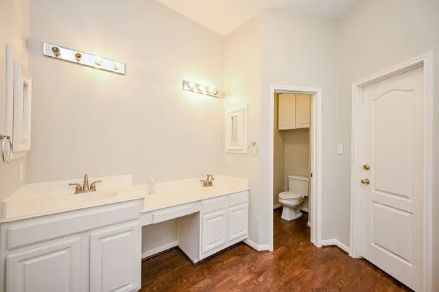 a bathroom with a double vanity sink mirror and toilet