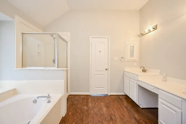 a bathroom with a tub sink and mirror
