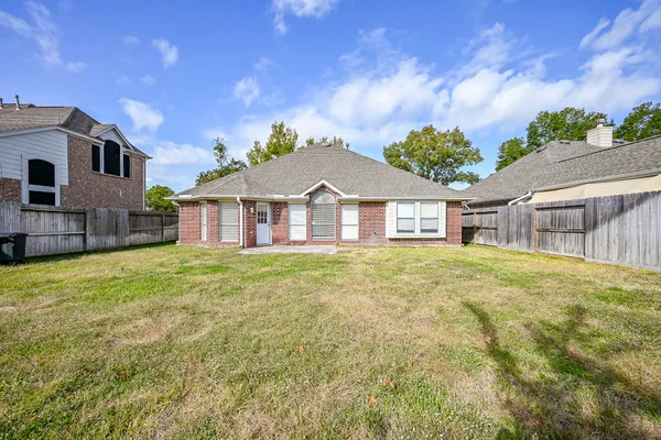 a view of a house with a backyard and a patio