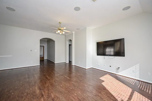 an empty room with wooden floor and windows