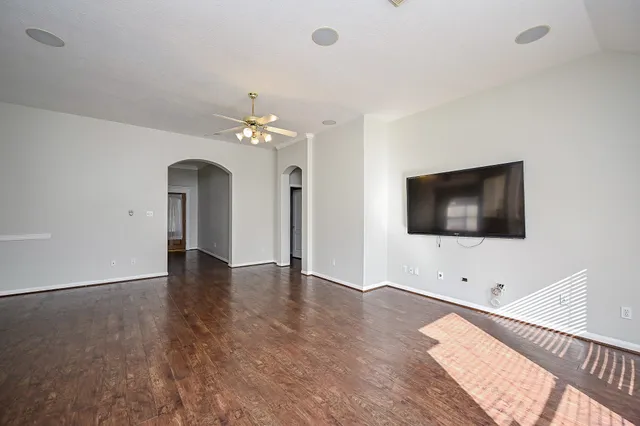 an empty room with wooden floor and windows
