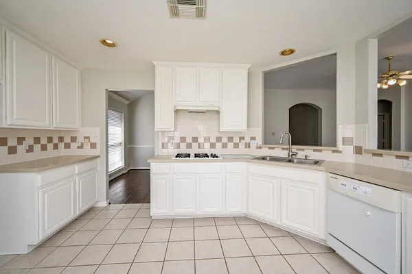 a large white kitchen with a sink and cabinets