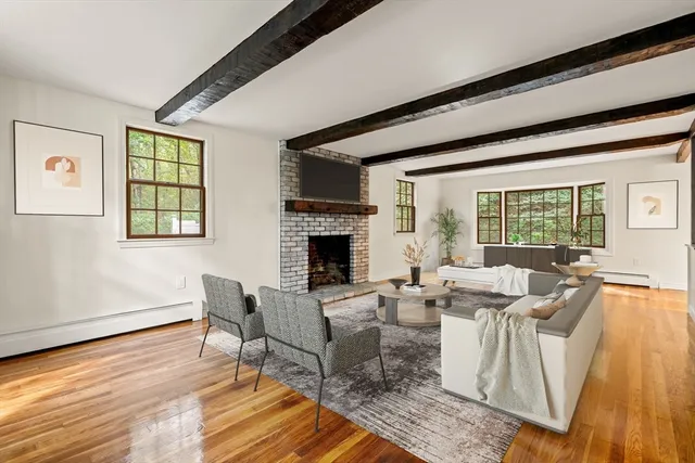 a living room with furniture large window and wooden floor