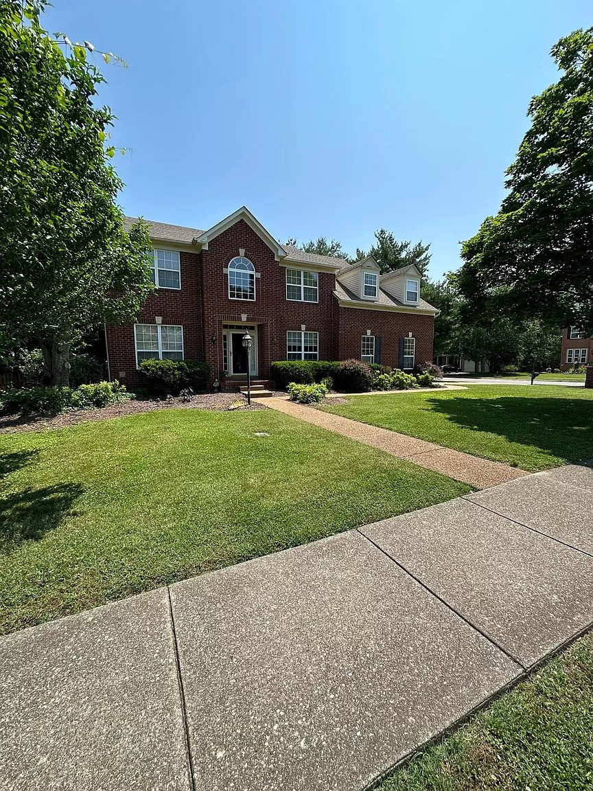 a front view of house with yard and green space