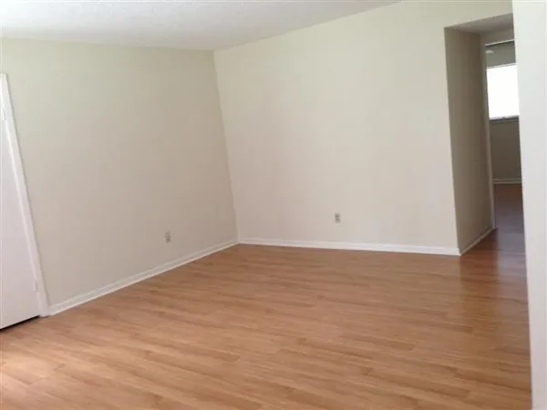 a view of an empty room with wooden floor