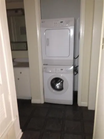 a utility room with wooden floor washer and dryer