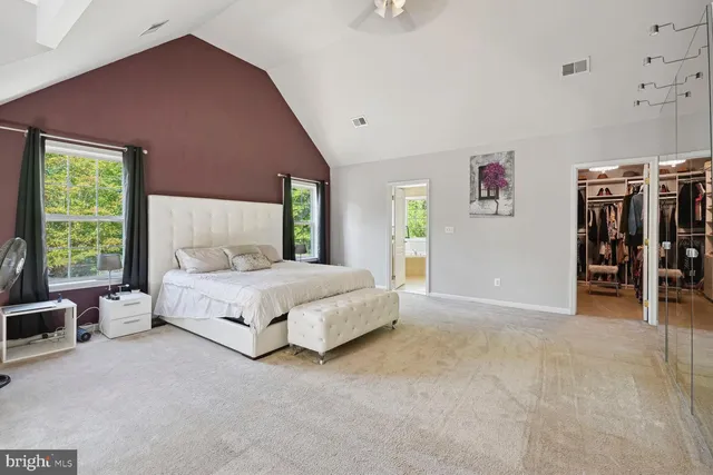 a spacious bedroom with a large bed and a large window