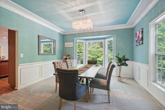 a dining room with furniture a chandelier and window
