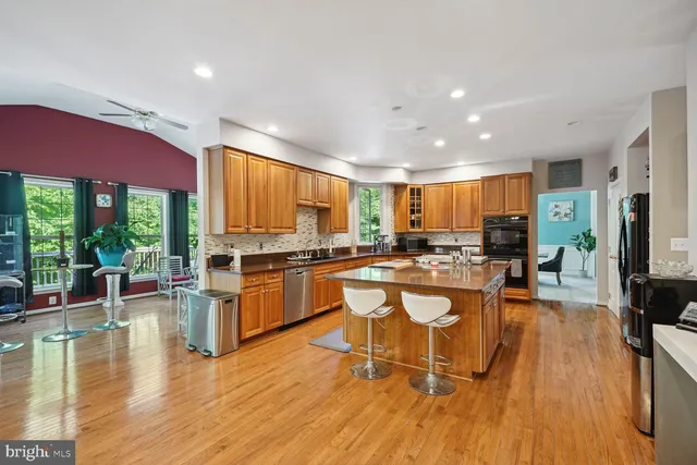 a kitchen with stainless steel appliances granite countertop wooden floors a stove and a sink