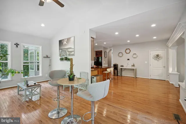 a living room with furniture floor to ceiling window and wooden floor