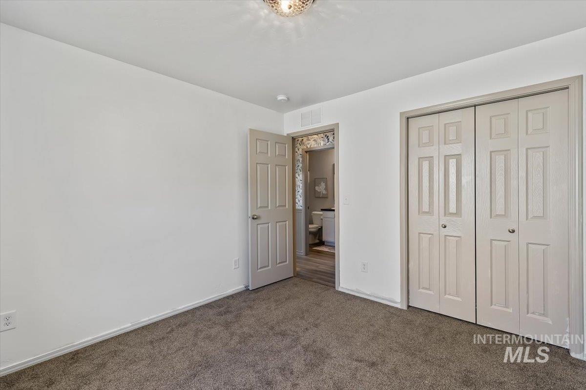 12781 Ashfield Street Caldwell, ID 83607 - Photo 30 of 36 Unfurnished bedroom with dark colored carpet and a closet
