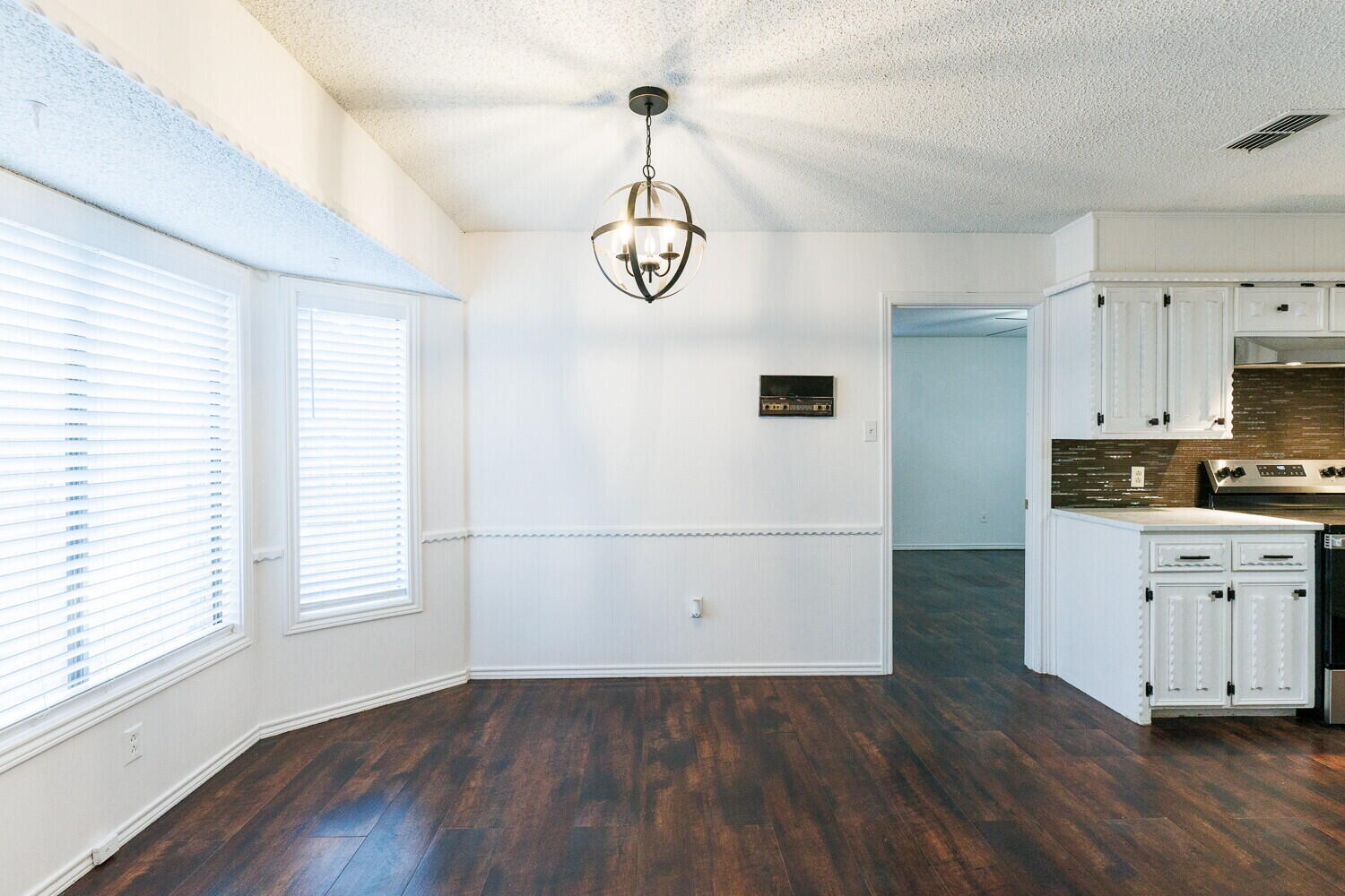4813 73rd Street Lubbock, TX 79424 - Photo 11 of 49 a view of a kitchen with wooden floor and white cabinets