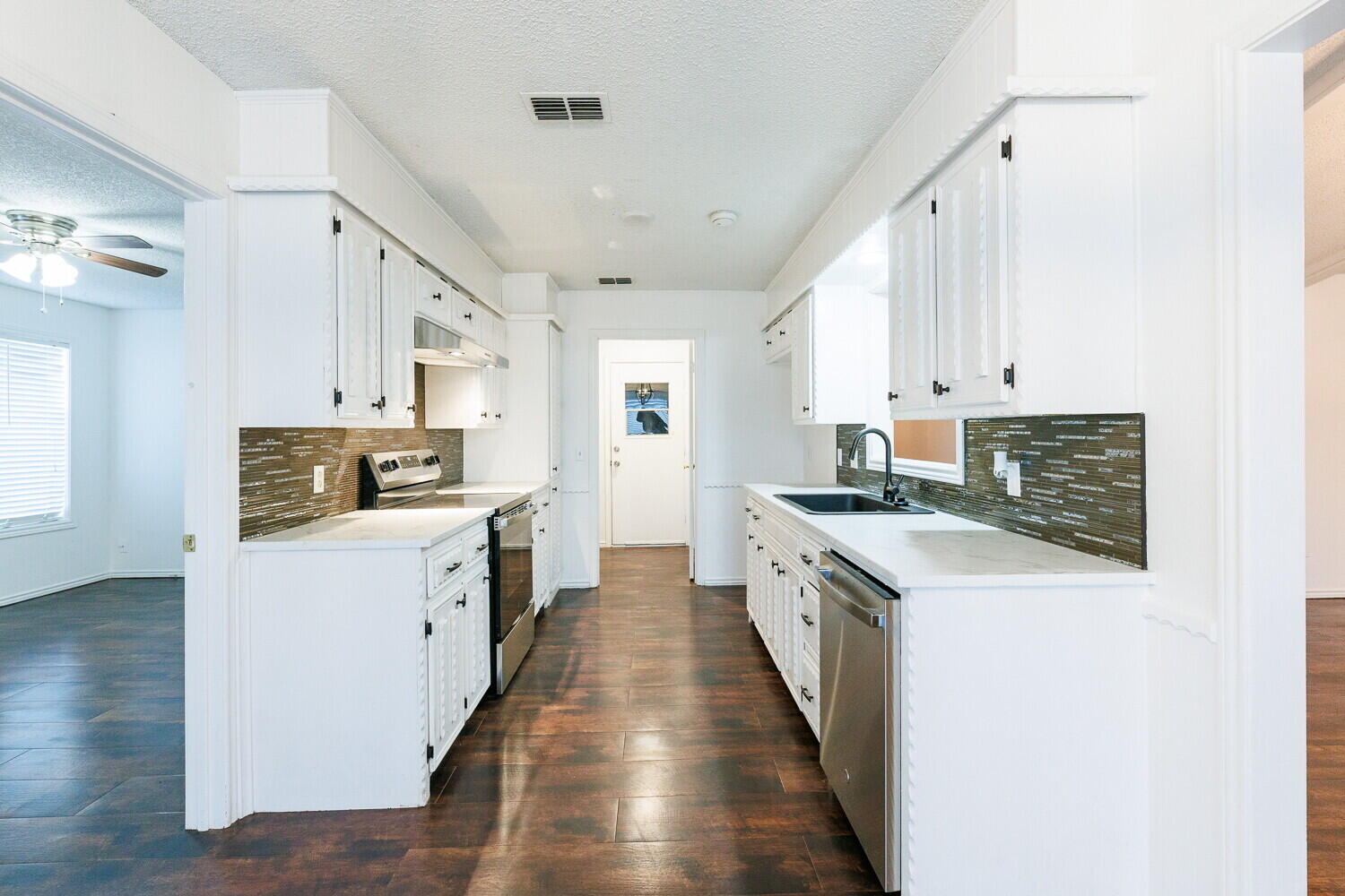 4813 73rd Street Lubbock, TX 79424 - Photo 15 of 49 a kitchen with white cabinets sink and stove