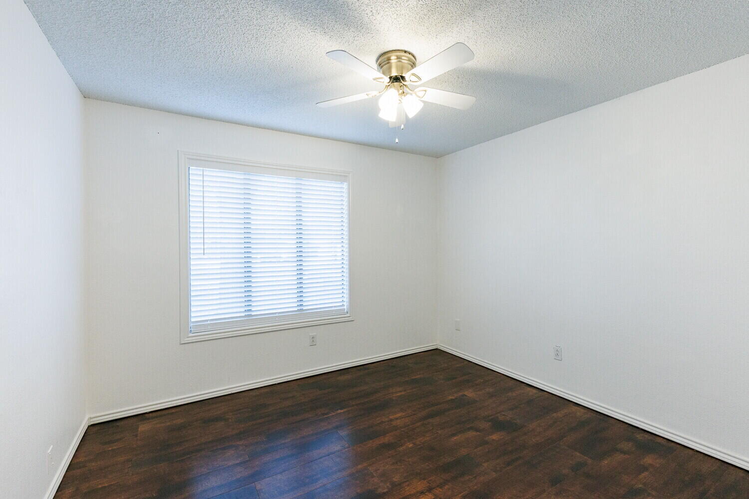 4813 73rd Street Lubbock, TX 79424 - Photo 39 of 49 an empty room with wooden floor and chandelier fan