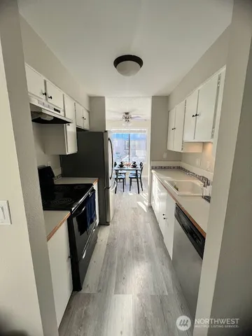 a kitchen with granite countertop a stove top oven a sink dishwasher and a microwave