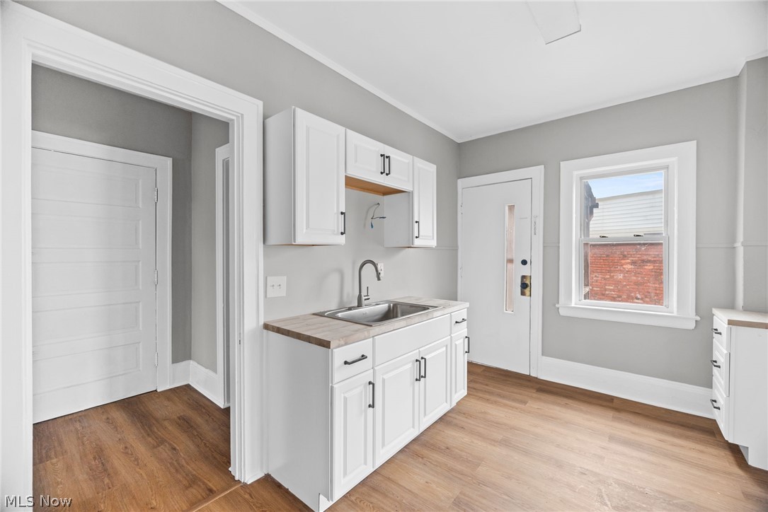 2140 Broadview Road Cleveland, OH 44109 - Photo 27 of 42 upper front unit Kitchen featuring wooden counters, light hardwood / wood-style floors, sink, and white cabinetry
