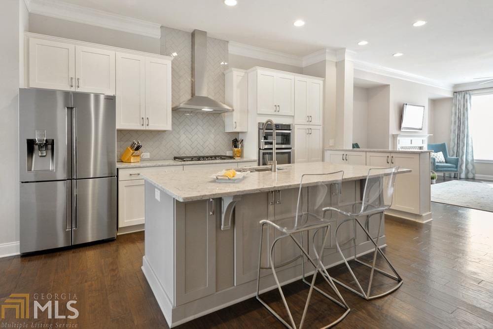 a kitchen with stainless steel appliances granite countertop a white cabinets and wooden floor