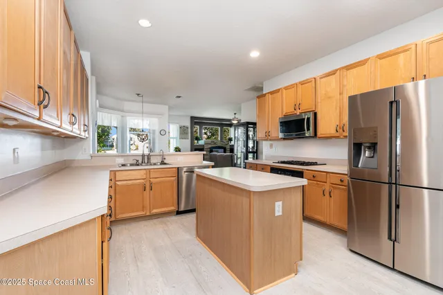 a kitchen with stainless steel appliances granite countertop a refrigerator stove microwave sink and cabinets