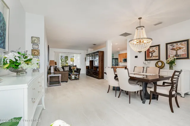 a view of a dining room with furniture and a chandelier