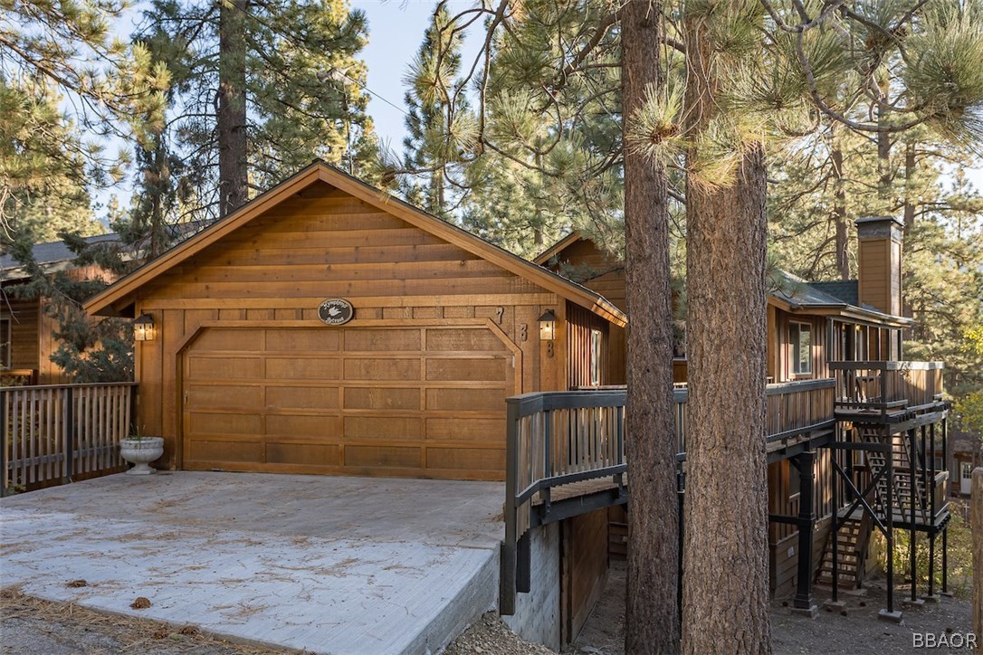 a view of a wooden house with large trees
