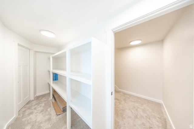 2169 Orchard Pines Loop East Bountiful, UT 84010 - Photo 26 of 32 Spacious walk-in closet featuring white built-in shelving, plush carpeting, and recessed lighting