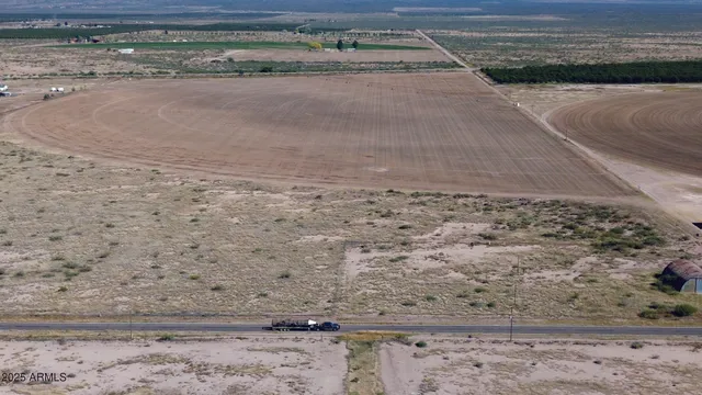a view of a dry yard with wooden fence