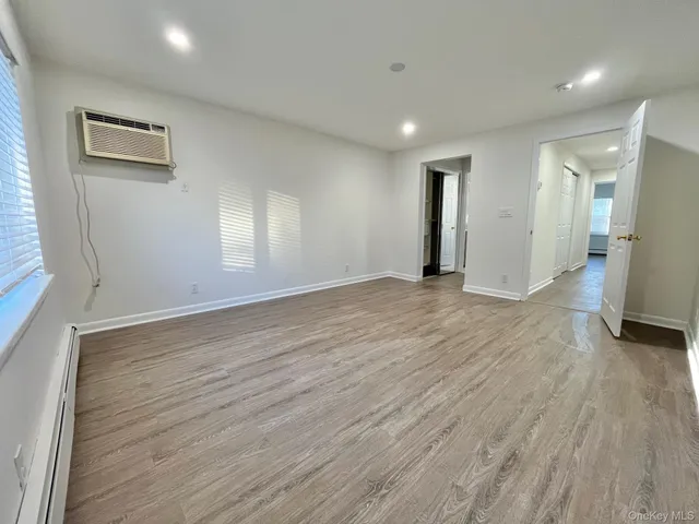 a view of an empty room with wooden floor