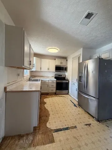 a kitchen with stainless steel appliances granite countertop a refrigerator sink and stove