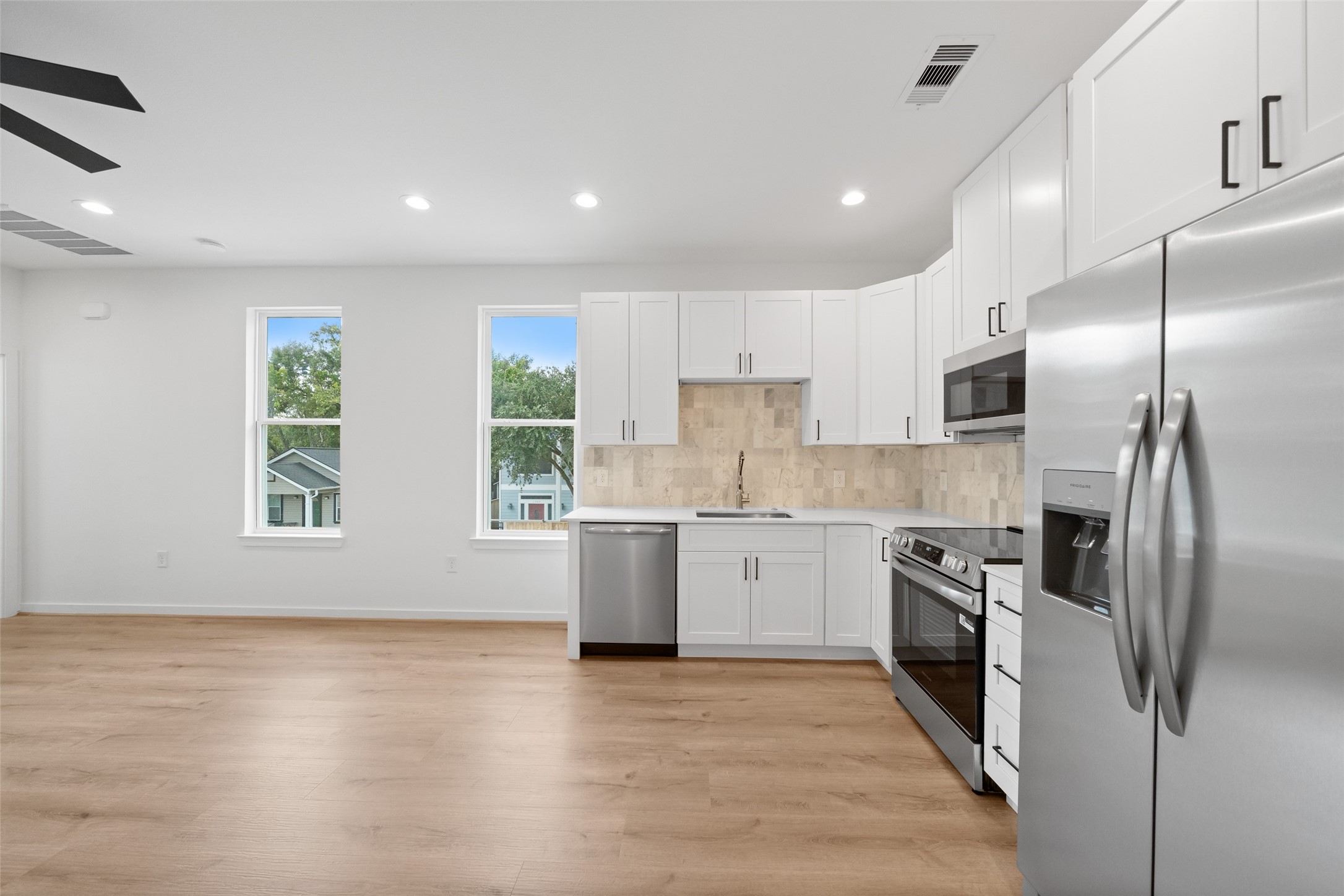 1408 Enid Street Houston, TX 77009 - Photo 17 of 50 a kitchen with granite countertop stainless steel appliances a sink and a refrigerator