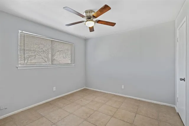 an empty room with a window and a fan