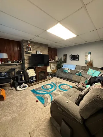 a living room with furniture a flat screen tv and kitchen view