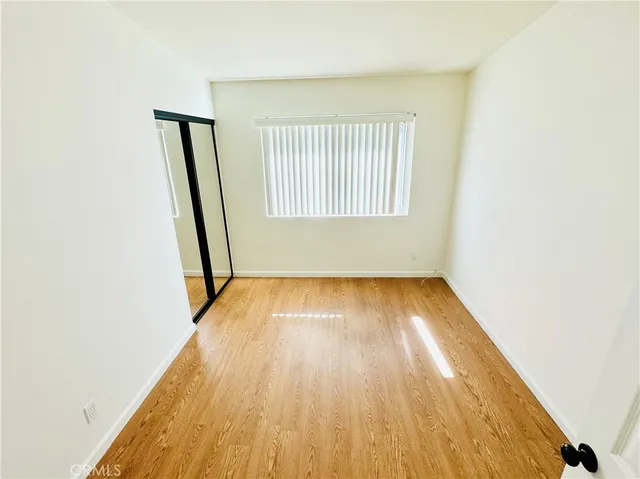 a view of an empty room with wooden floor and walls