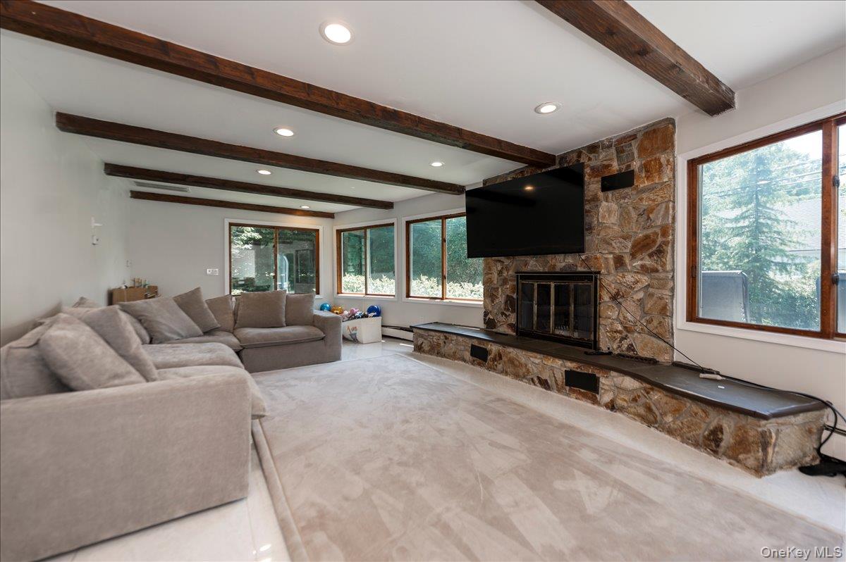 70 Longfellow Road Great Neck, NY 11023 - Photo 15 of 28 a living room with furniture a fireplace and a flat screen tv