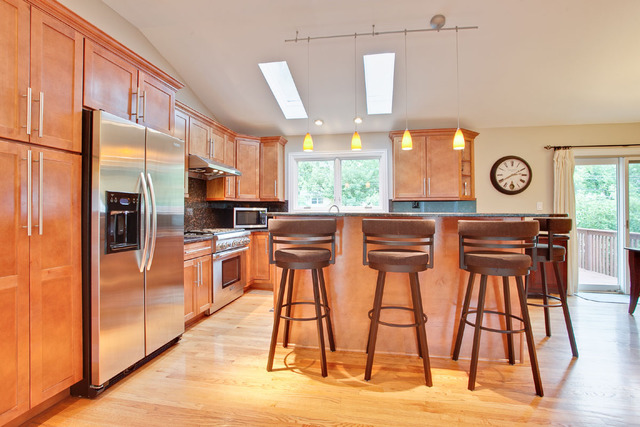 1212 Kenton Road Deerfield, IL 60015 - Photo 5 of 24 a kitchen with stainless steel appliances granite countertop a stove top oven a sink a dining table and chairs with wooden floor