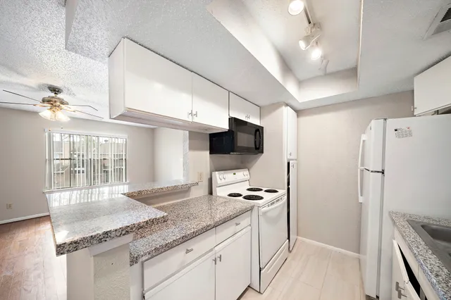 a kitchen with stainless steel appliances granite countertop a refrigerator a sink and a stove