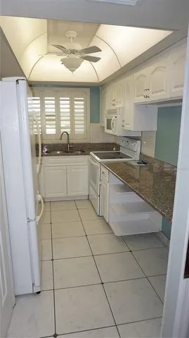 a kitchen with stainless steel appliances granite countertop a sink and a white cabinets