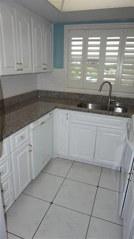 a kitchen with granite countertop a sink and a stove top oven