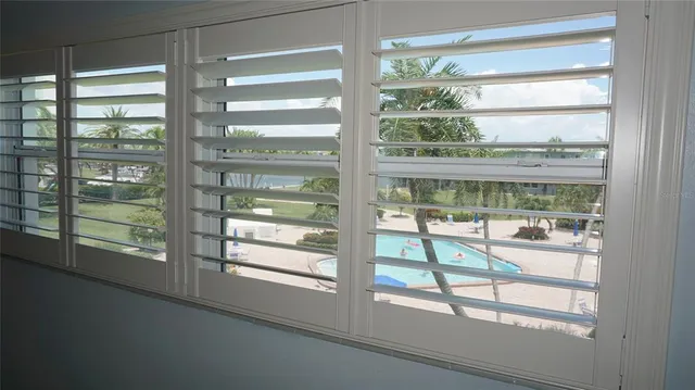 an empty room with wooden floor closet and fan