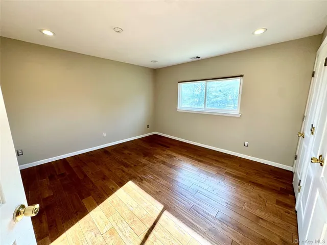 a view of a big room with wooden floor and windows