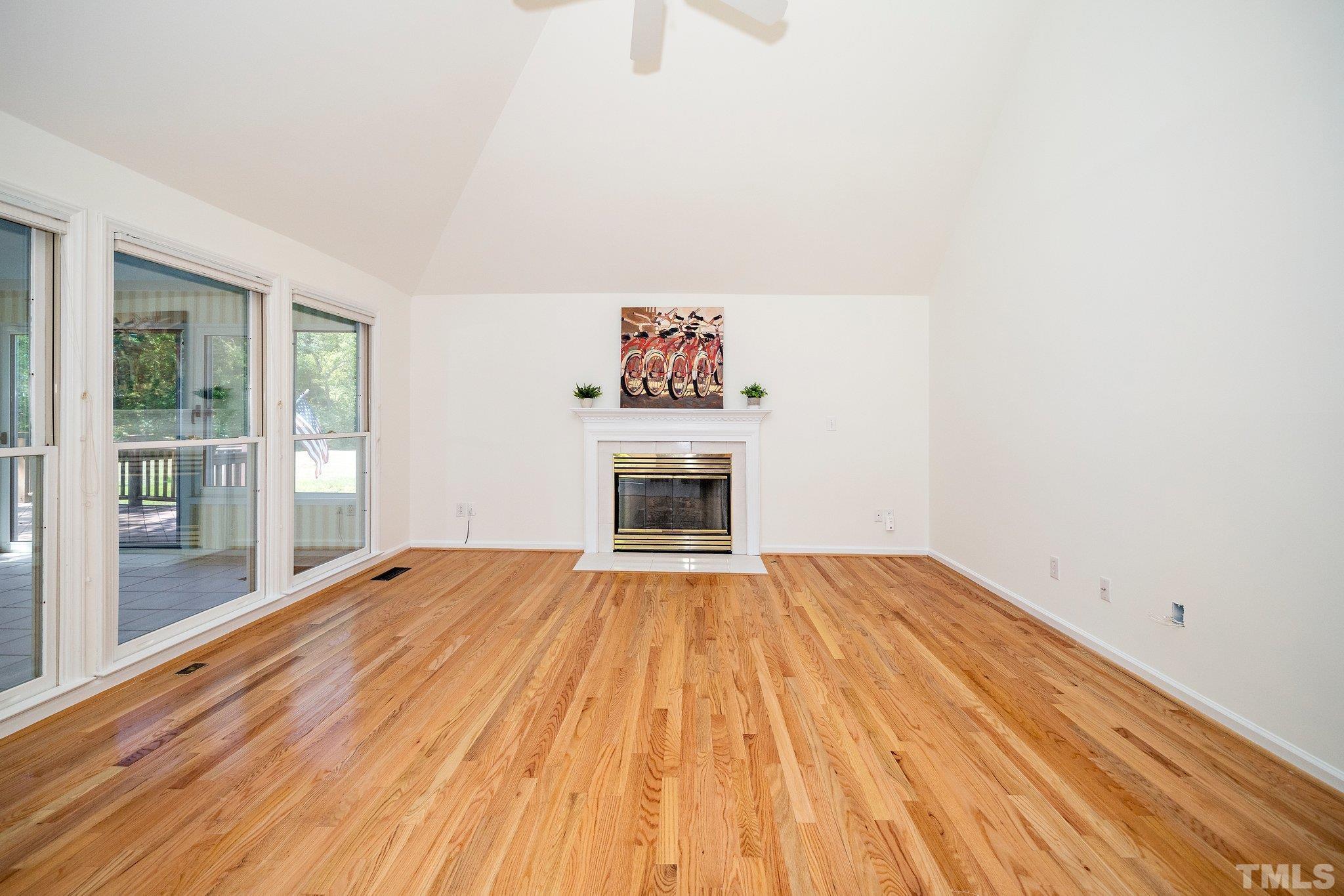 7801 Hogan Drive Wake Forest, NC 27587 - Photo 20 of 51 a view of empty room with wooden floor and fireplace