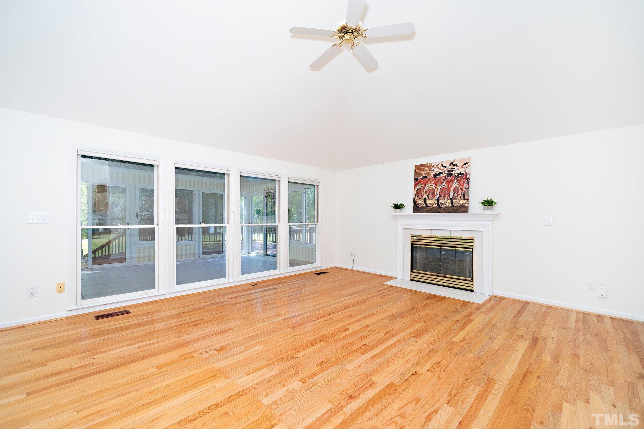 7801 Hogan Drive Wake Forest, NC 27587 - Photo 21 of 51 a view of empty room with a fireplace and wooden floor