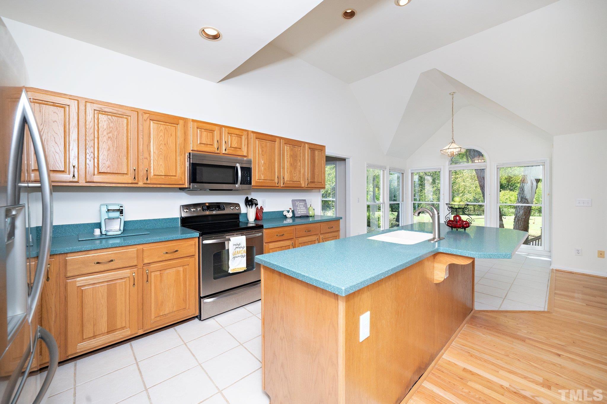 7801 Hogan Drive Wake Forest, NC 27587 - Photo 25 of 51 a kitchen with stainless steel appliances granite countertop a stove top oven a sink dishwasher and a microwave oven on the blue kitchen countertops