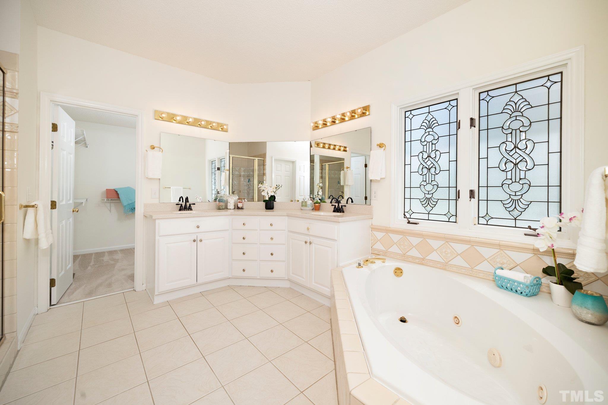 7801 Hogan Drive Wake Forest, NC 27587 - Photo 33 of 51 a spacious bathroom with a tub sink and mirror