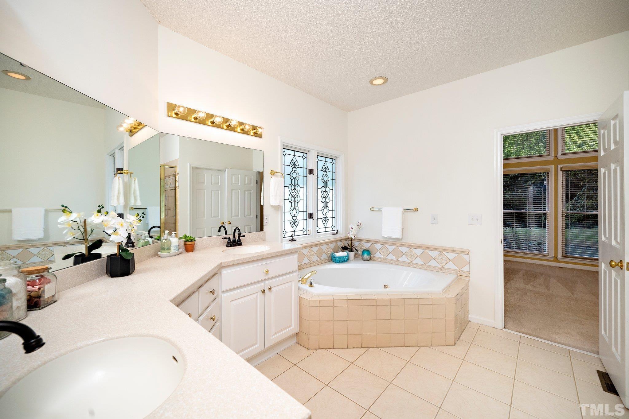 7801 Hogan Drive Wake Forest, NC 27587 - Photo 34 of 51 a large bathroom with a tub sink and mirror