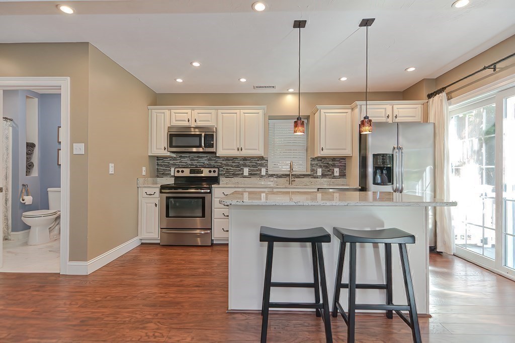 9 Broadway Stoneham, MA 02180 - Photo 35 of 42 a kitchen with stainless steel appliances granite countertop a stove a sink and a refrigerator