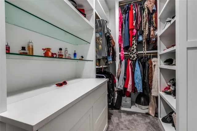 a view of walk in closet with clothes