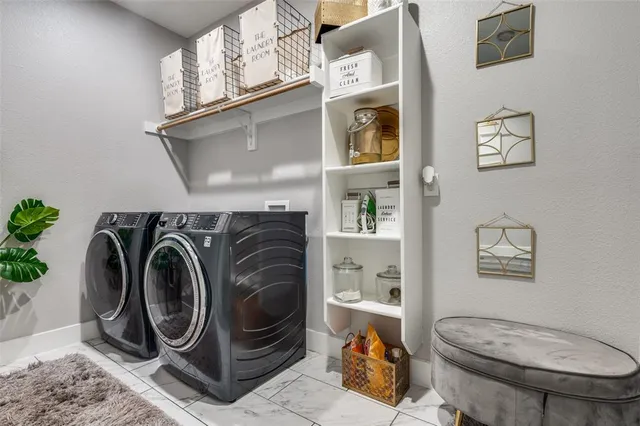 a utility room with dryer washer and a view of bathroom