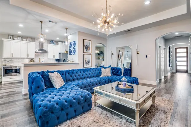 a living room with furniture a chandelier and a table